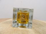 a small square glass candle holder on a wooden table