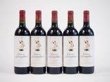 four bottles of red wine are lined up on a white surface