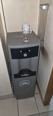a water dispenser in the corner of a bathroom