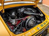 a yellow car with an engine in it ' s trunk