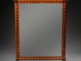an antique wooden mirror with a carved frame on a stand