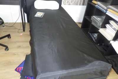un lit recouvert d'un couvre-lit noir dans une chambre