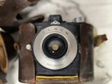 a close up of an old camera with a leather case