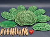 a green plate with a cabbage on it next to other plates and spoons