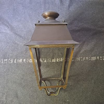an image of a small brass lantern hanging from a wall