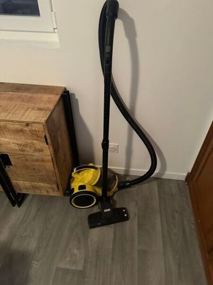 l'aspirateur est posé par terre, à côté d'une armoire en bois