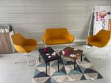 trois chaises et une table dans une pièce où il y a un tapis au sol