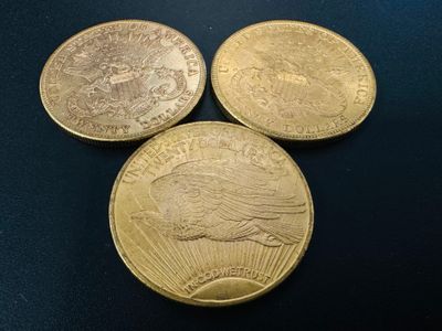 three gold coins sitting on top of each other on a table