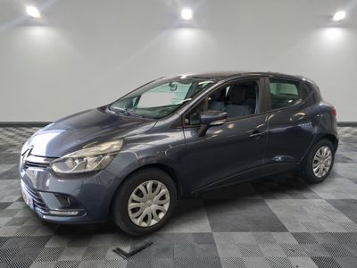a grey car is parked on a checkered floor in a garage