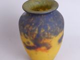 a blue and yellow vase sitting on a white surface
