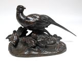 une statue en bronze représentant un oiseau posé sur un rocher