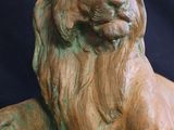 a bronze statue of a lion sitting on a rock