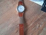 a watch that is sitting on a table next to a book