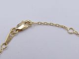 a close up of a gold chain bracelet on a white surface