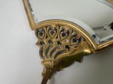 a mirror with a gold frame and a mirror with a bird on it