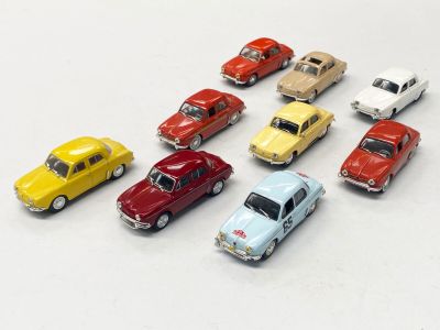 plusieurs petites voitures sont alignées sur une surface blanche