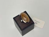 un gros plan d'une bague posée sur une boîte munie d'une étiquette
