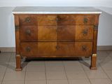 a marble top chest of drawers in the corner of a room