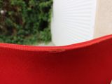 une chaise rouge qui se trouve dehors, sur le trottoir