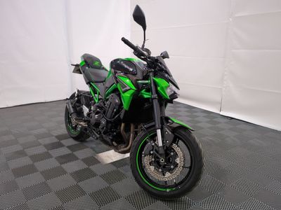 une photo d'une moto verte et noire garée dans un garage