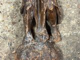 une statue représentant un chien posé sur un rocher au sol