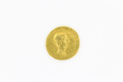 gros plan d'une pièce d'or sur une surface blanche