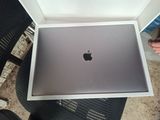 une boîte contenant un ordinateur portable Apple, posée sur une table