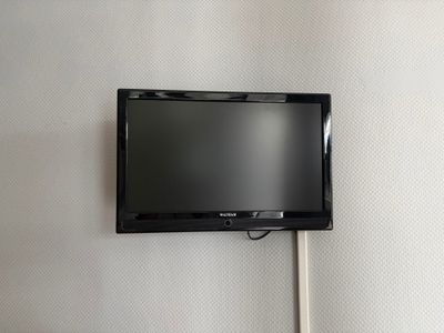 une télévision à écran plat fixée au mur au-dessus d'un lit