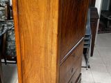 a tall wooden cabinet with a mirror on top of it