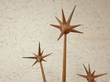 three wooden stars on a stand against a white wall