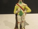 a figurine of a man with a green hat and yellow jacket