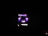un diamant violet dans l'obscurité, éclairé par une lumière