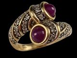 a close up of a gold ring with two ruby stones