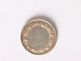a small coin on a white surface with a white background