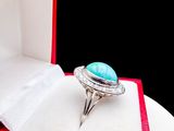 a ring in a red box with a turquoise stone in it