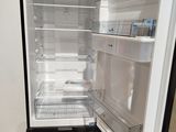a black refrigerator with its door open in a room