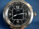 a silver clock with a black face on a blue background