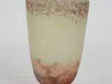 a glass vase with a brown base on a white surface