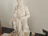 a statue of a man sitting on top of a table