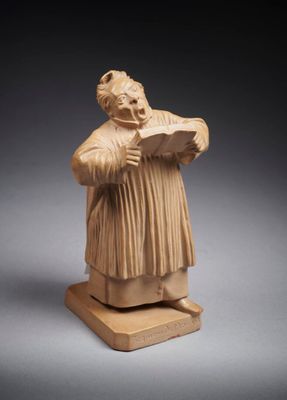 une statue représentant un homme tenant un livre dans ses mains