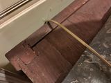 a piece of wood on the floor next to a wall