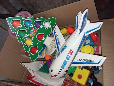 une boîte en carton remplie de jouets et un petit avion en jouet