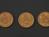 three different types of gold coins on a black surface