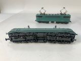 two green trains sitting side by side on a white surface
