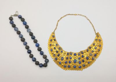 two necklaces and a bead necklace on a white surface