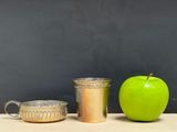 an apple, a cup, and a mug sitting on a table