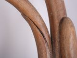 a close up view of a wooden chair with a curved seat