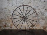 une grande roue métallique posée sur une table en bois