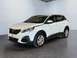 Une voiture blanche est garée dans une grande pièce.