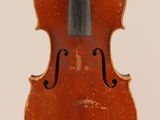 an old violin sitting on top of a white surface